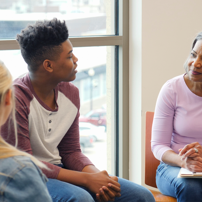 Harris Center staff member engaging a group of juveniles in a group counseling setting