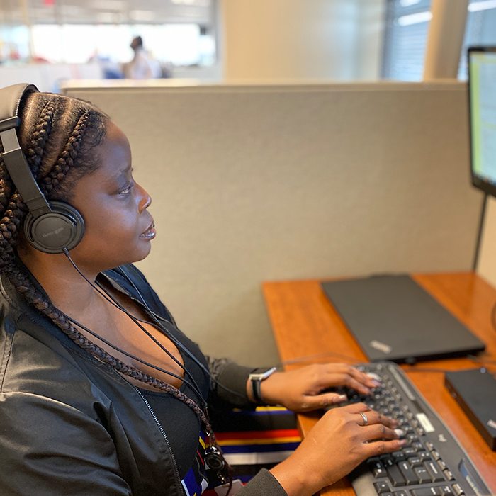 A photo depicting a woman working in a call center.