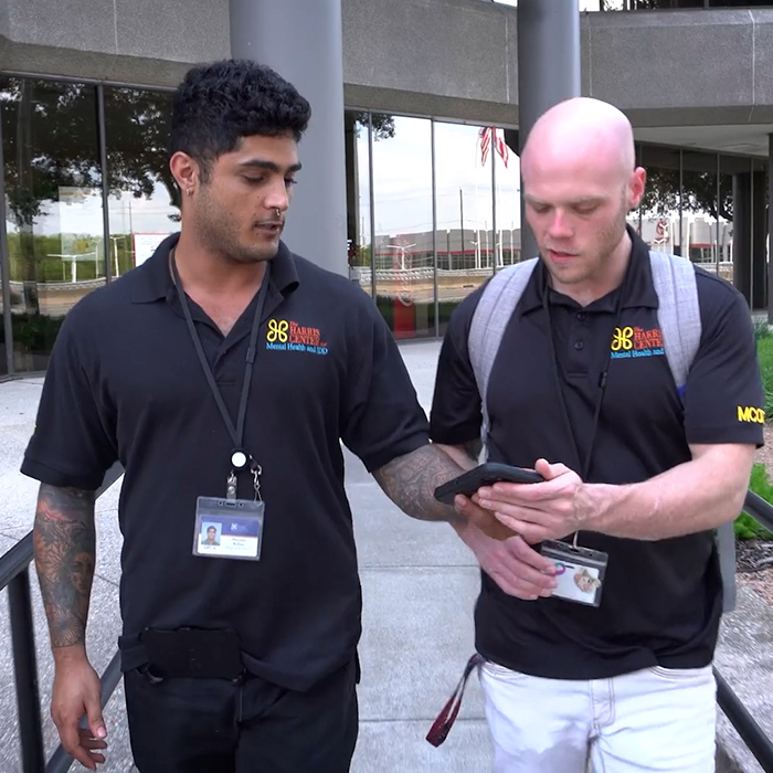 A photo of two members of the Rapid Response team examining something on a smartphone.