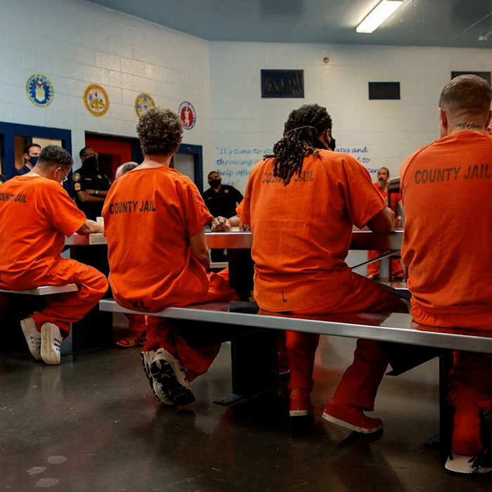 A photo of several Harris County Jail inmates gathered in a cafeteria. 