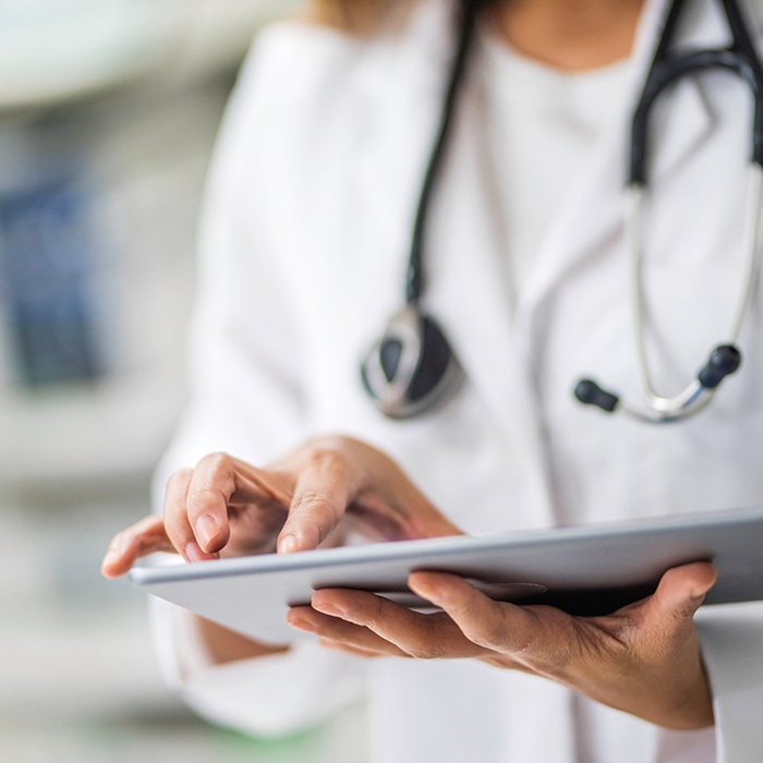 A stock photo of a clinician using a tablet device.