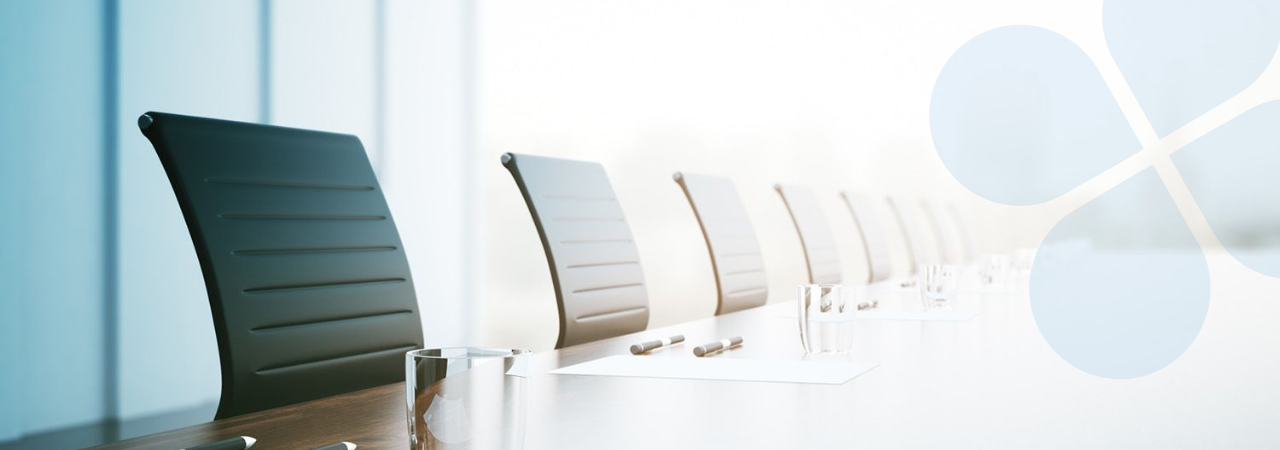 Low shot of chairs pushed up to a long board room table