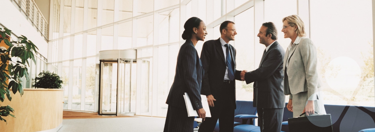 Business people greeting one another in a bright open lobby of an office building