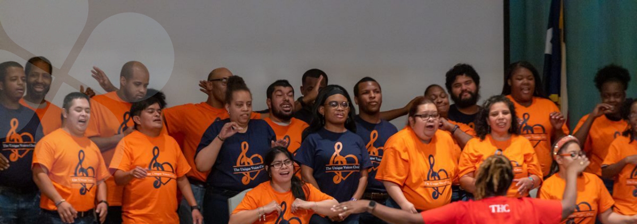 Choir members wearing matching t-shirts, performing for loved-ones and acquaintances