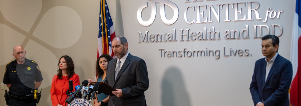 The Harris Center CEO, Wayne Young, and others gathered near the podium at a press event
