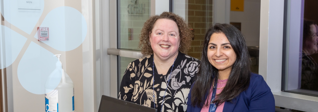 Two Harris Center staff members posing in an office environment