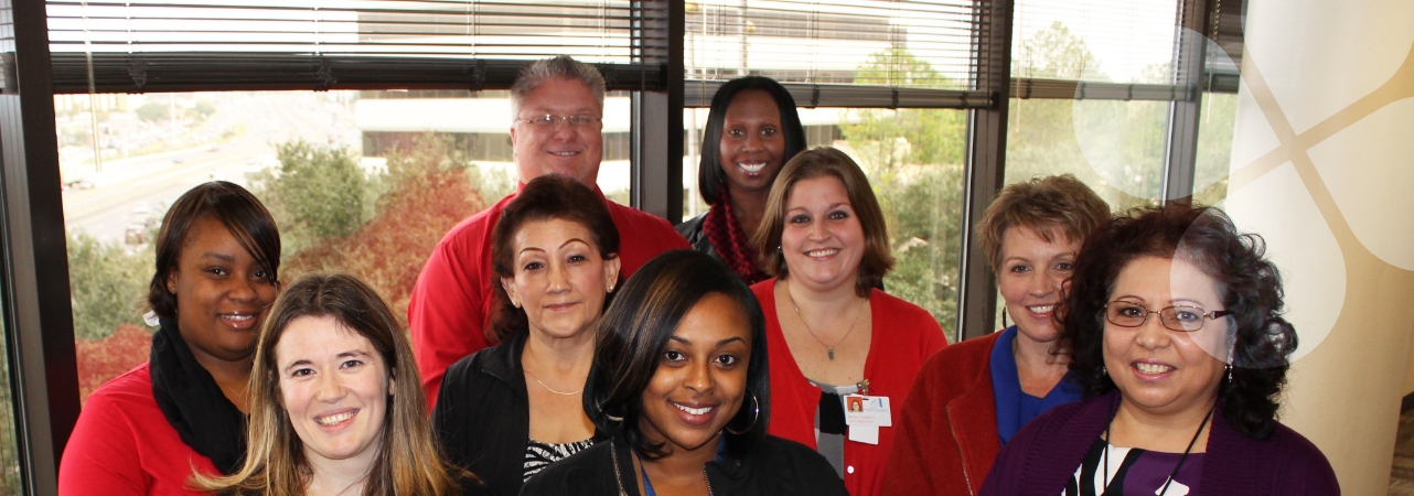 Harris Center staff members posing for a group photo in an office hallway environment