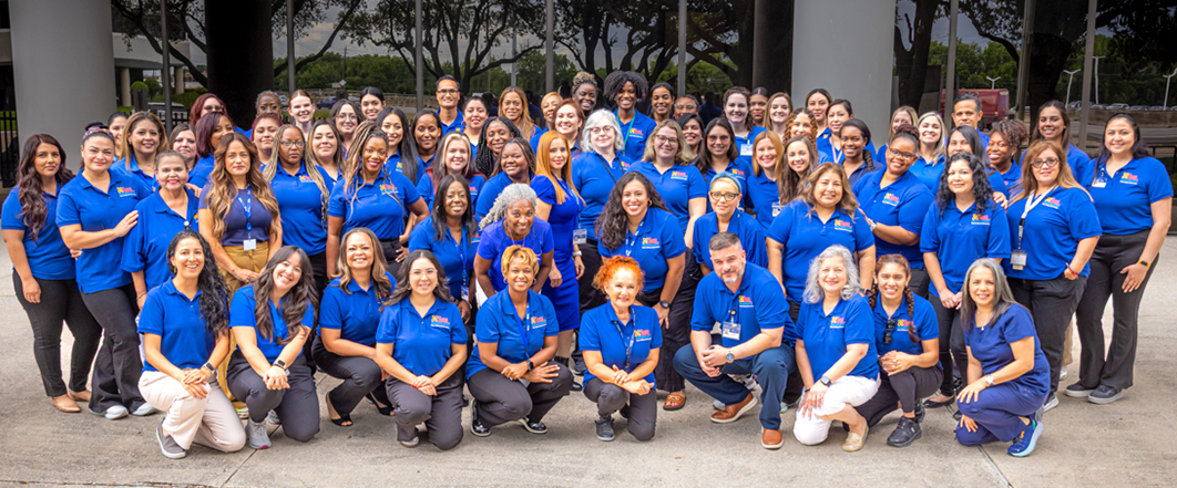Large group of ECI team members smiling and wearing their blue uniforms.