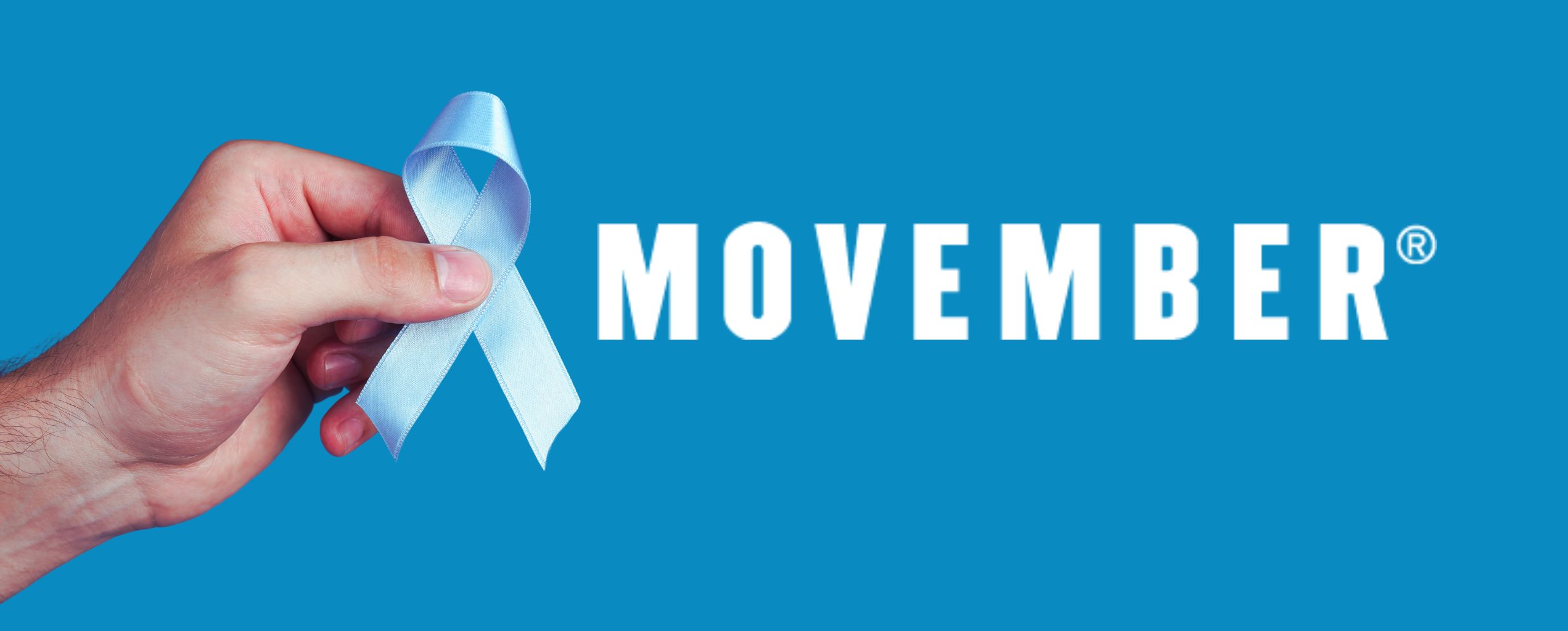A hand holding a light blue awareness ribbon next to the word “MOVEMBER” on a bright blue background, symbolizing men’s health awareness month.