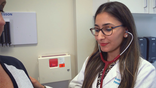 Harris Center healthcare provider using a stethoscope on a patient in a clinic setting